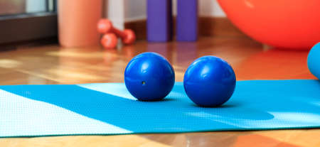 Fitness equipment. Pilates mat and exercise weights on wooden floorの写真素材