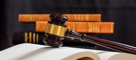 Law gavel on an open book, wooden desk, law books backgroundの写真素材