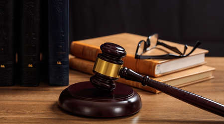 Law gavel on a wooden desk, law books backgroundの写真素材