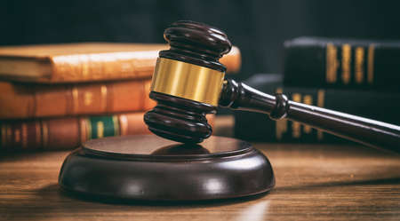Law gavel on a wooden desk, law books backgroundの写真素材