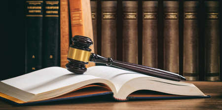 Law gavel on an open book, wooden desk, law books backgroundの写真素材