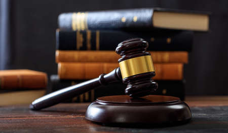Law gavel on a wooden desk, law books backgroundの写真素材