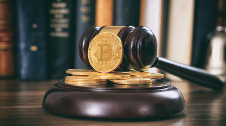 Law or auction gavel and bitcoins on a wooden desk, dark backgroundの写真素材