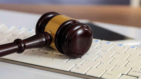 Online auction concept. Auction or judge gavel on a computer keyboardの写真素材