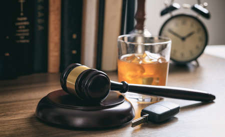 DUI concept. Law gavel, alcohol and car keys on a wooden desk, dark backgroundの写真素材