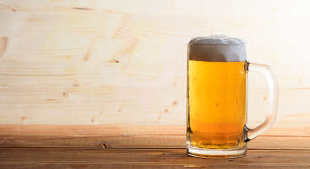 A glass full of beer on a wooden background, copy spaceの写真素材