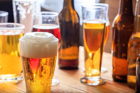 A full frosty glass of beer on a wooden pub counterの写真素材