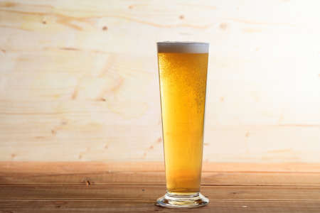 A glass full of beer on a wooden background, copy spaceの写真素材