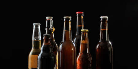 Collection of unopened beer bottles on black backgroundの写真素材