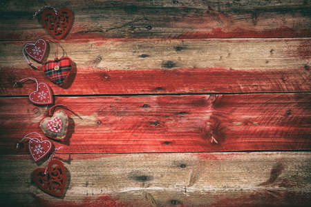 Decorative hearts on red wooden background, top viewの写真素材