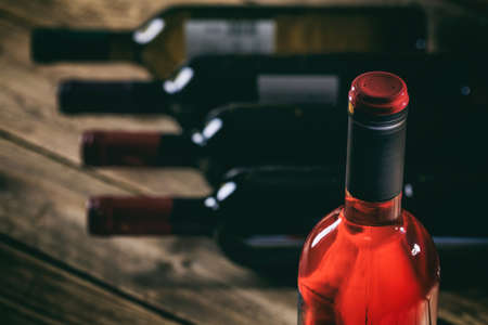 Rose wine bottle on a wooden table, wine bottles collection backgroundの写真素材