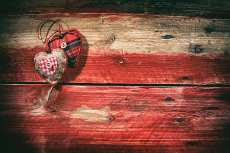 Decorative hearts on red wooden background, top viewの写真素材