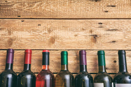Wine bottles collection on wooden background, copy space, top viewの写真素材