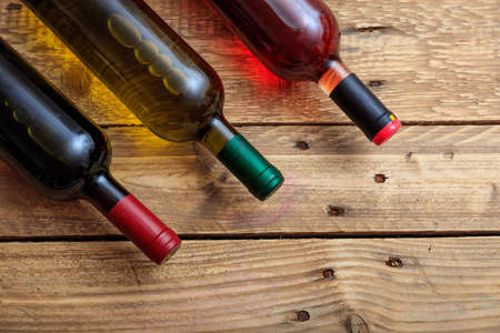 Wine bottles collection on wooden background, copy space, top viewの写真素材