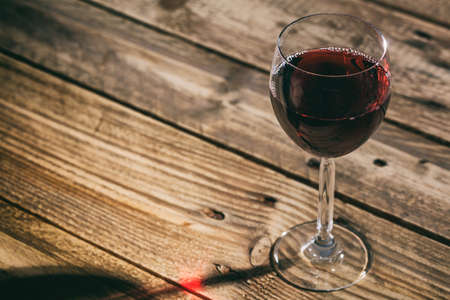 Red wine glass on a wooden table, copy spaceの写真素材