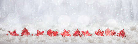 Red Christmas ornaments on abstract cold winter background with snowの写真素材