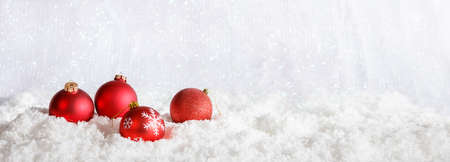 Red Christmas balls on abstract cold winter background with snowの写真素材