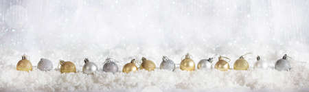 Christmas balls on abstract cold winter background with snow and defocused lightsの写真素材