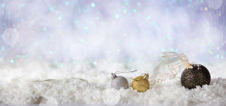 Christmas balls on abstract cold winter background with snow and defocused lightsの写真素材