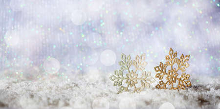 Christmas snowflakes on abstract cold winter background with snow and defocused lightsの写真素材