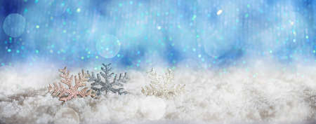 Christmas snowflakes on abstract cold winter background with snow and defocused lightsの写真素材