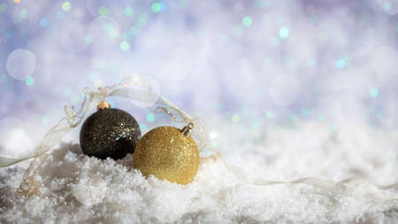 Christmas balls on abstract cold winter background with snow and defocused lightsの写真素材