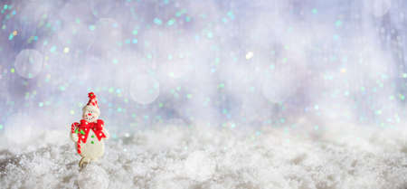 Christmas snowman on abstract cold winter background with snow and defocused lightsの写真素材
