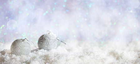 Christmas balls on abstract cold winter background with snow and defocused lightsの写真素材