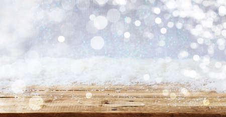 Wooden surface and Christmas snowy bokeh backgroundの写真素材