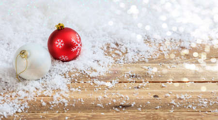 Christmas balls on a wooden table, snowy bokeh background, copy spaceの写真素材