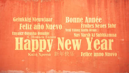 Happy new year wish in many languages on stucco painted wall backgroundの写真素材