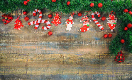 Christmas ornaments and green garland on a wooden board, copy spaceの写真素材