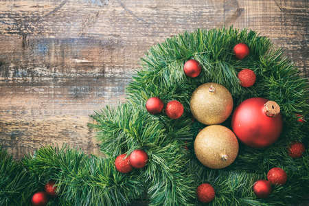 Christmas balls and green garland on a wooden board, copy spaceの写真素材