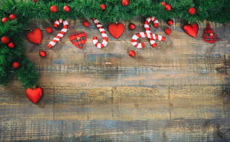 Christmas ornaments and green garland on a wooden board, copy spaceの写真素材