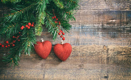 Christmas red hearts and green garland on a wooden board, copy spaceの写真素材