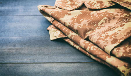 American military digital pattern uniform, folded on wooden background with copy spaceの写真素材