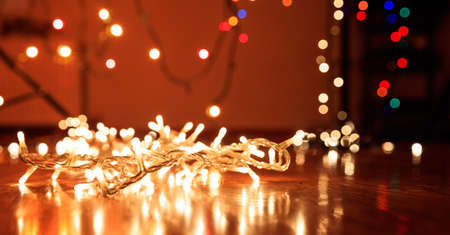 Christmas lights on wooden floor, bokeh background,の写真素材