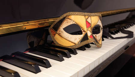 Handmade carnival mask on classical piano keyboardの写真素材