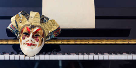 Carnival mask on classical piano keyboard, front viewの写真素材