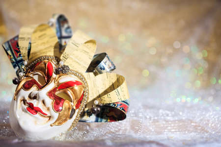 Harlequin Carnival mask on white surface, abstract bokeh backgroundの写真素材