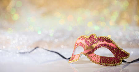 Pink carnival mask on white surface, abstract bokeh backgroundの写真素材