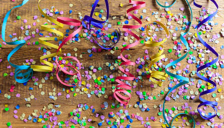 Party concept. Colorful carnival confetti and serpentines on wooden background, top niewの写真素材