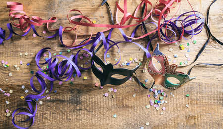 Carnival party. Masks, confetti and serpentines on wooden background, top niew, copy spaceの写真素材
