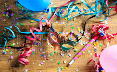 Carnival party. Mask, confetti and serpentines on wooden background, top niewの写真素材