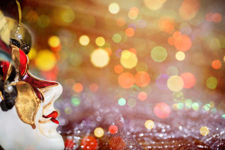 Harlequin Carnival mask on white surface, abstract bokeh backgroundの写真素材