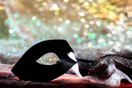 Black carnival mask on colorful bokeh backgroundの写真素材