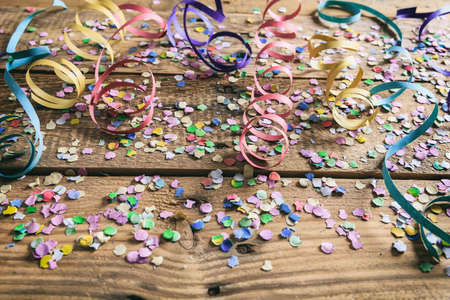 Party concept. Colorful confetti and serpentines on wooden backgroundの写真素材