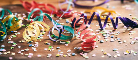 Carnival party. Colorful confetti and serpentines on wooden backgroundの写真素材