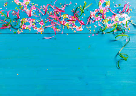 Colorful carnival confetti and serpentines on blue wooden background, top niew, copy spaceの写真素材
