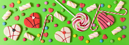Colorful candies on bright green background, top viewの写真素材